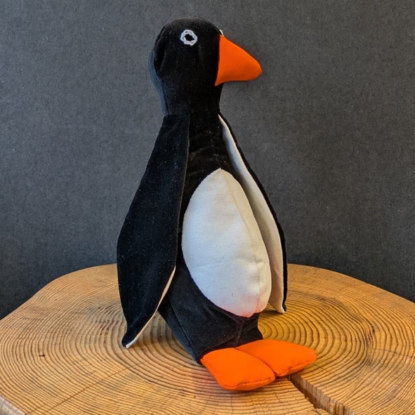 Pingviini on lystik&auml;s pehmoel&auml;in, jolla on veike&auml; ilme.